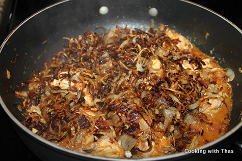 adding fried onions to chicken