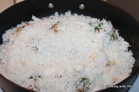 adding rice to biryani