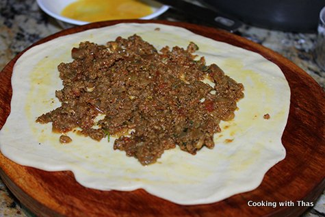 spread ground beef masala on dough